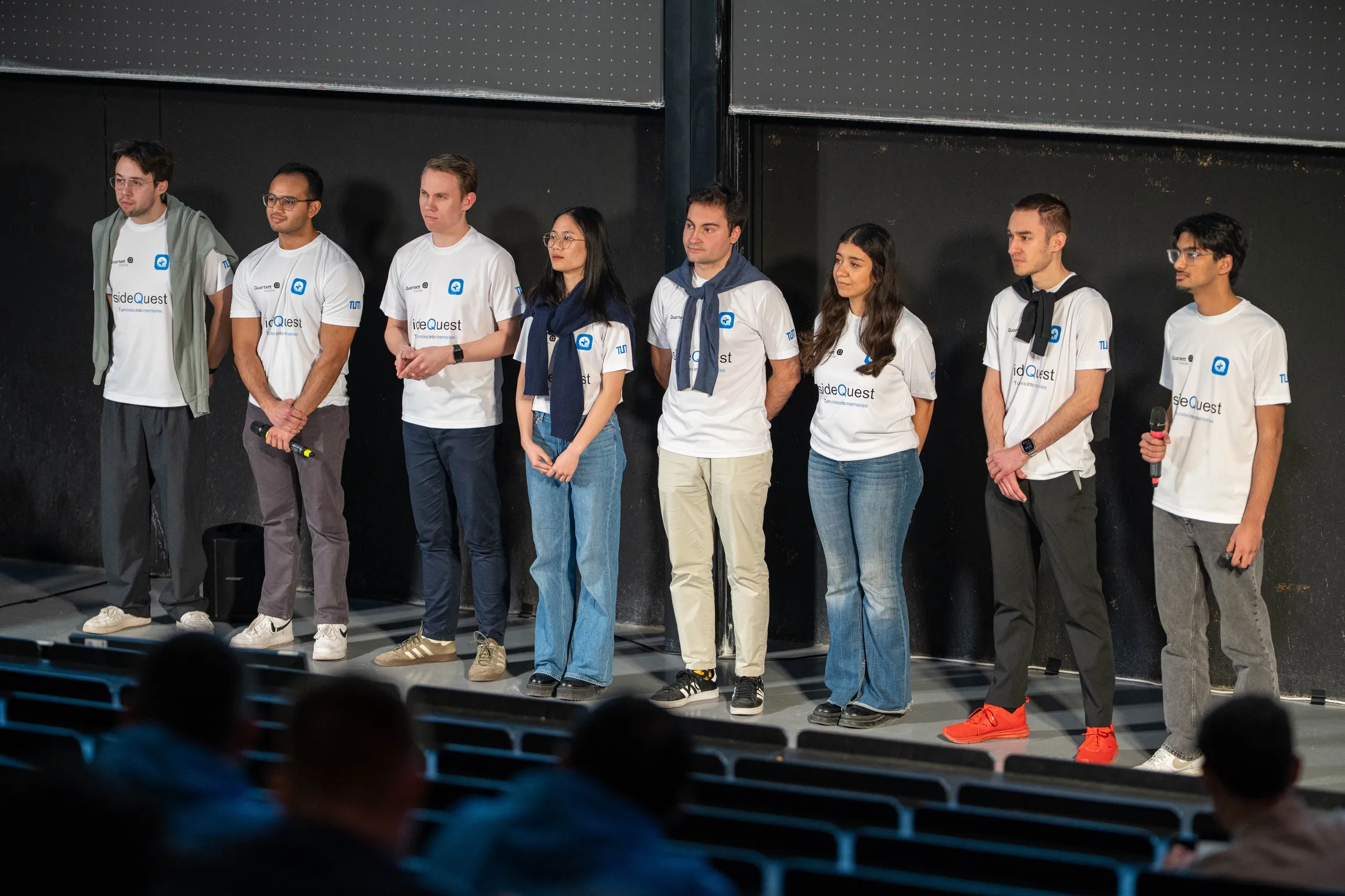 The sideQuest team on stage at the Client Acceptance Test in custom jerseys