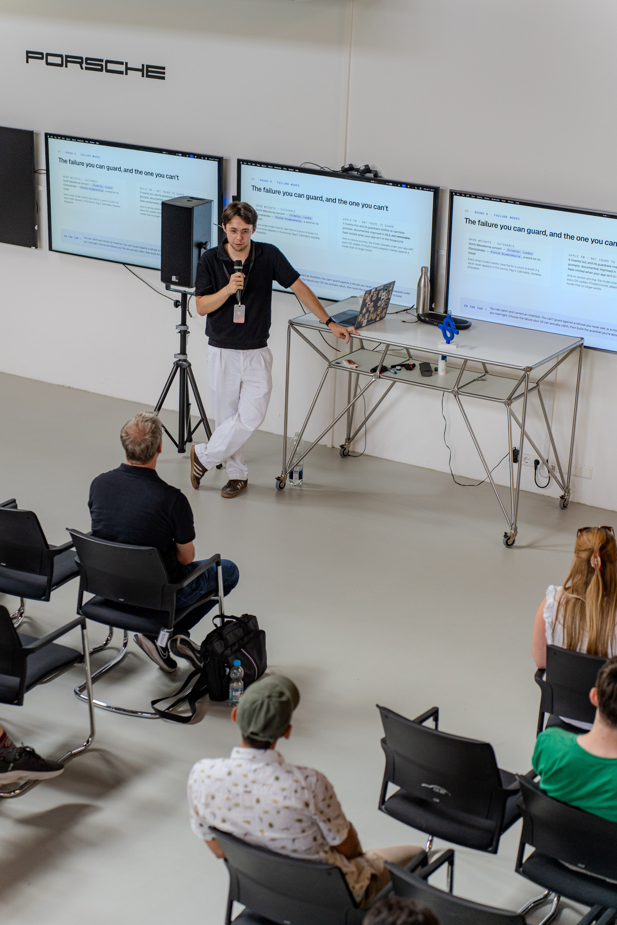 Justin Lanfermann speaking beside a slide titled The failure you can guard, and the one you cannot during the Porsche Tech Day talk